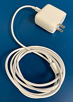 Picture of an apple charging block, which has a large square 'brick' that plugs into the wall, inside is a transformer.