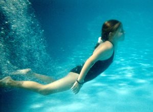 An underwater picture of a girl after she dove into the water.
