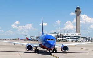 A photograph of a Denver Airline airplane on the runway on a clear day